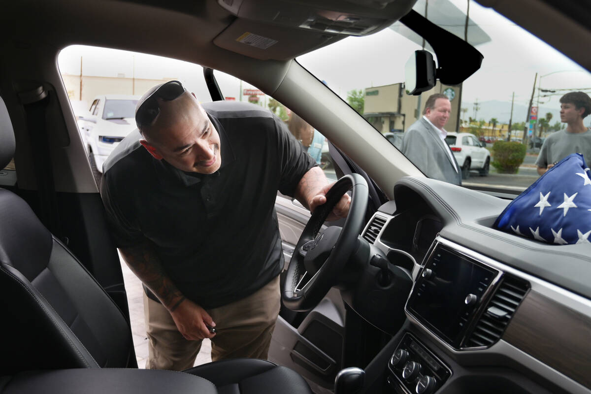 Retired Navy corpsman Ruben Cervantez checks out the interior of his new car after being presen ...