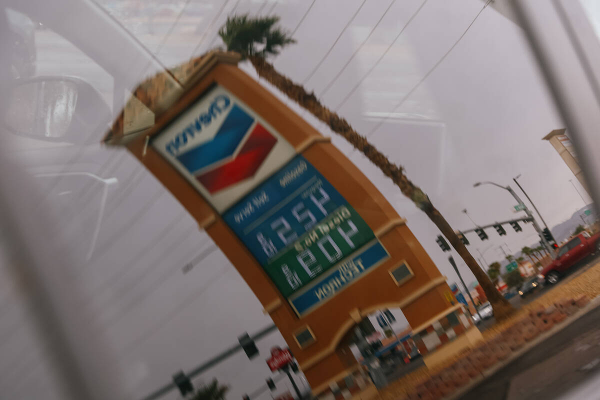 A car window reflects a sign displaying gas prices at a Chevron gas station on Thursday, Sept. ...