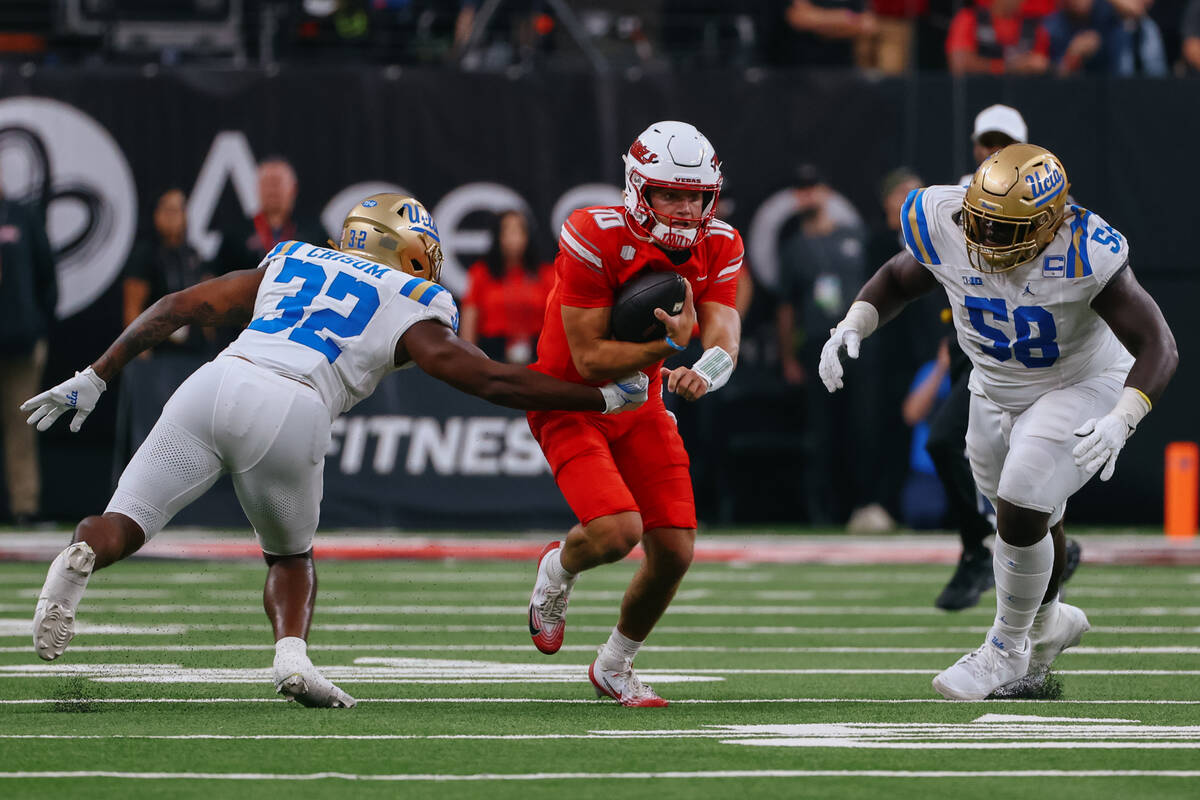 UNLV quarterback Anthony Colandrea (10) darts in between UCLA linebacker Isaiah Chisom (32) and ...