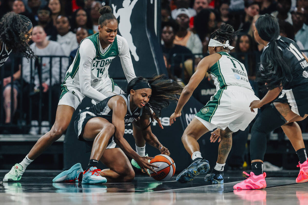 Aces guard Jackie Young (0) gets into a scuffle for the ball during game three of a first round ...