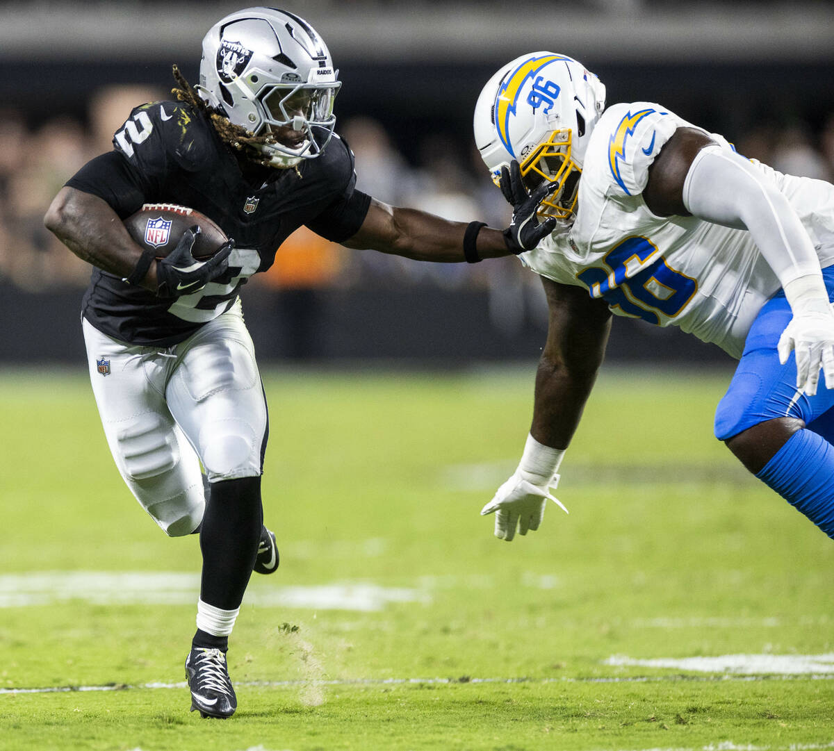 Raiders running back Ashton Jeanty (2) breaks a tackle attempt by Los Angeles Chargers defensiv ...