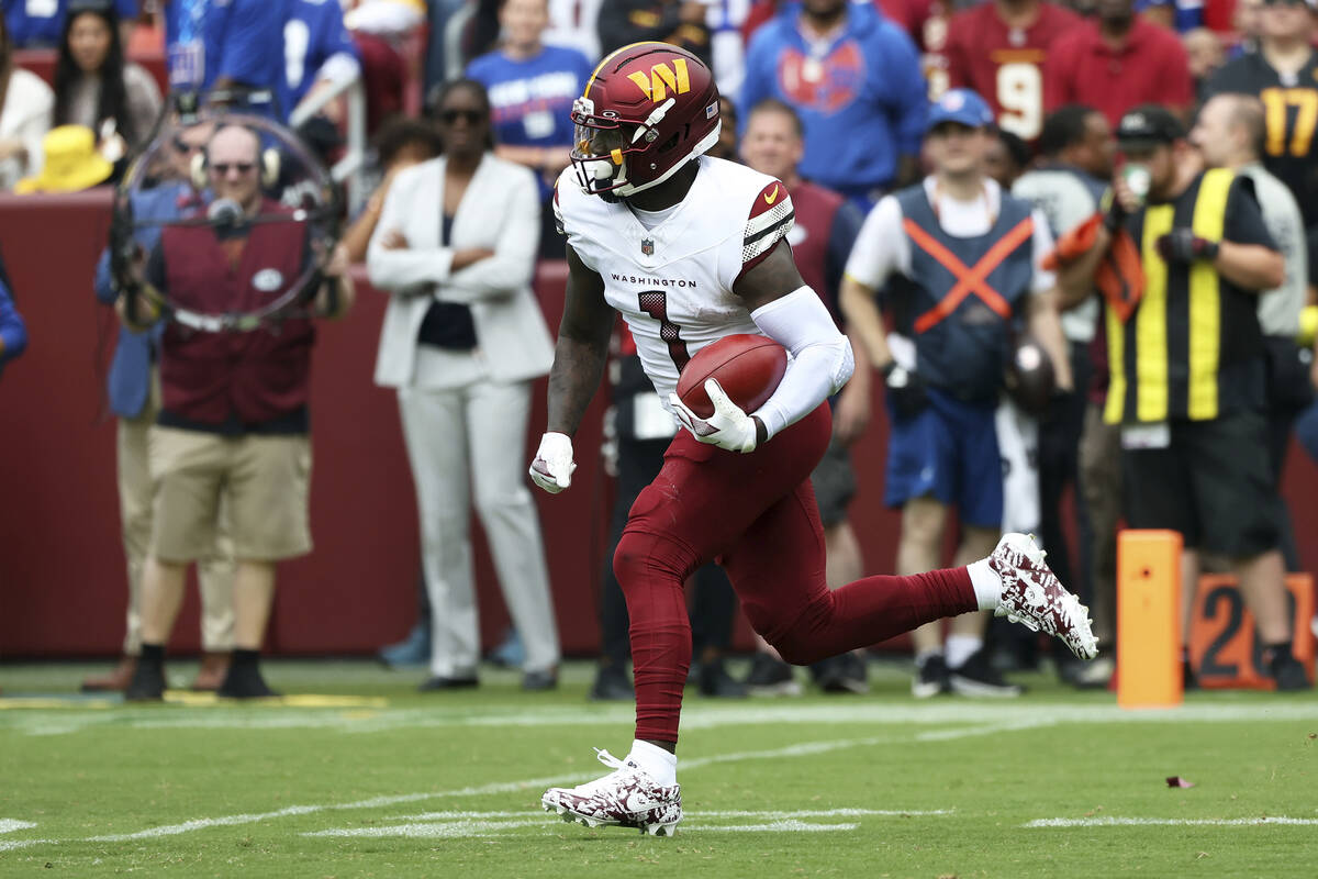 Washington Commanders wide receiver Deebo Samuel (1) runs with the ball during an NFL football ...