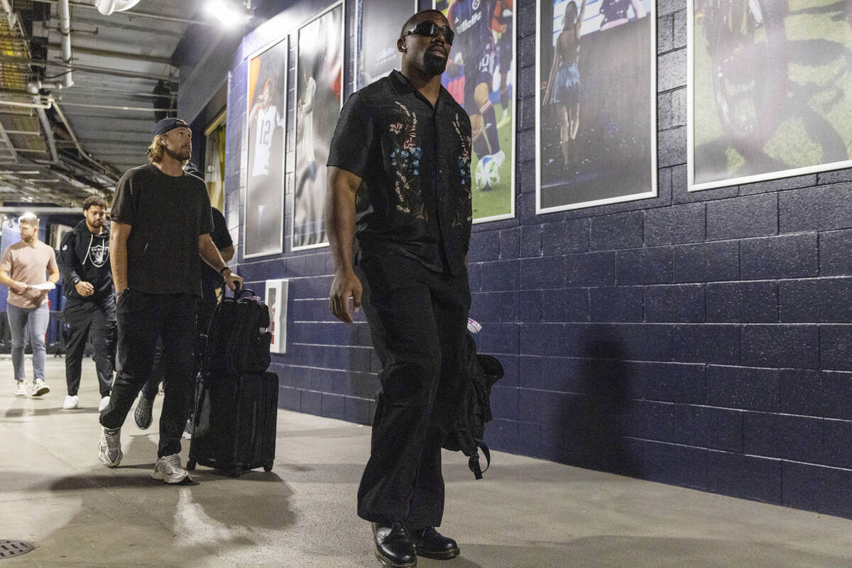 Raiders defensive tackle Thomas Booker IV, front, and punter AJ Cole arrive at Gillette Stadium ...