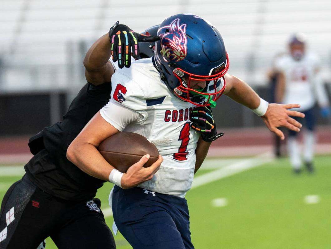 Coronado’s quarterback Jackson Humphries (1) holds back Desert Oasis’s Eric Johns ...