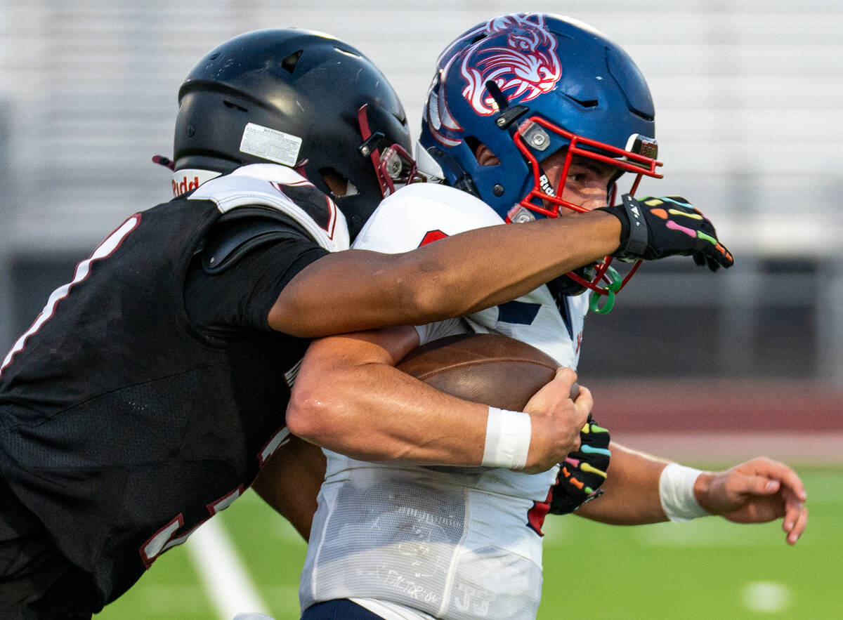 Coronado’s quarterback Jackson Humphries (1) holds back Desert Oasis’s Eric Johns ...