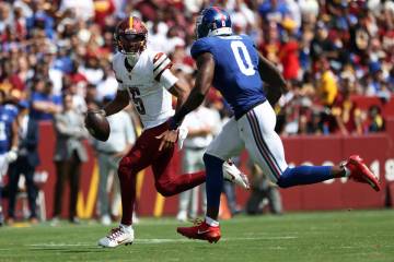 Washington Commanders quarterback Jayden Daniels (5) runs with the ball during an NFL football ...