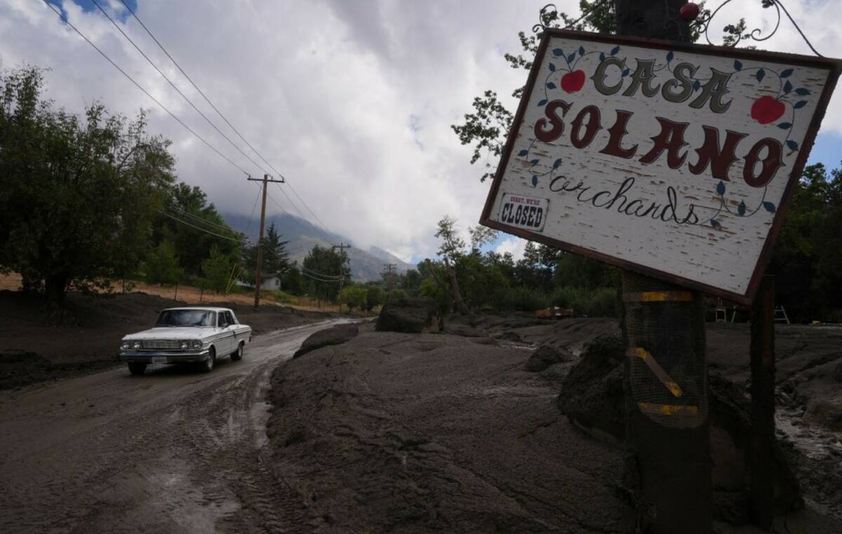 Workers clean up the damage caused by mudslides after storms in Yucaipa, Calif., Friday, Sept. ...