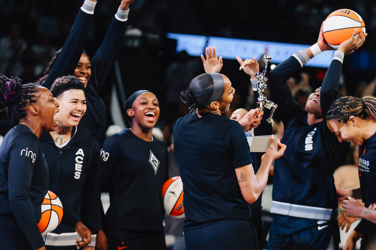 Aces center A'ja Wilson shows off her map trophy to her team during game one of a round tw ...