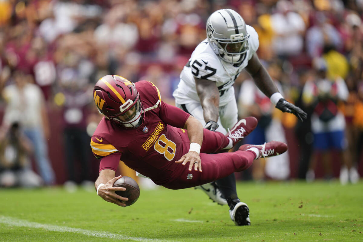 Washington Commanders quarterback Marcus Mariota (8) scores a touchdown as Las Vegas Raiders li ...