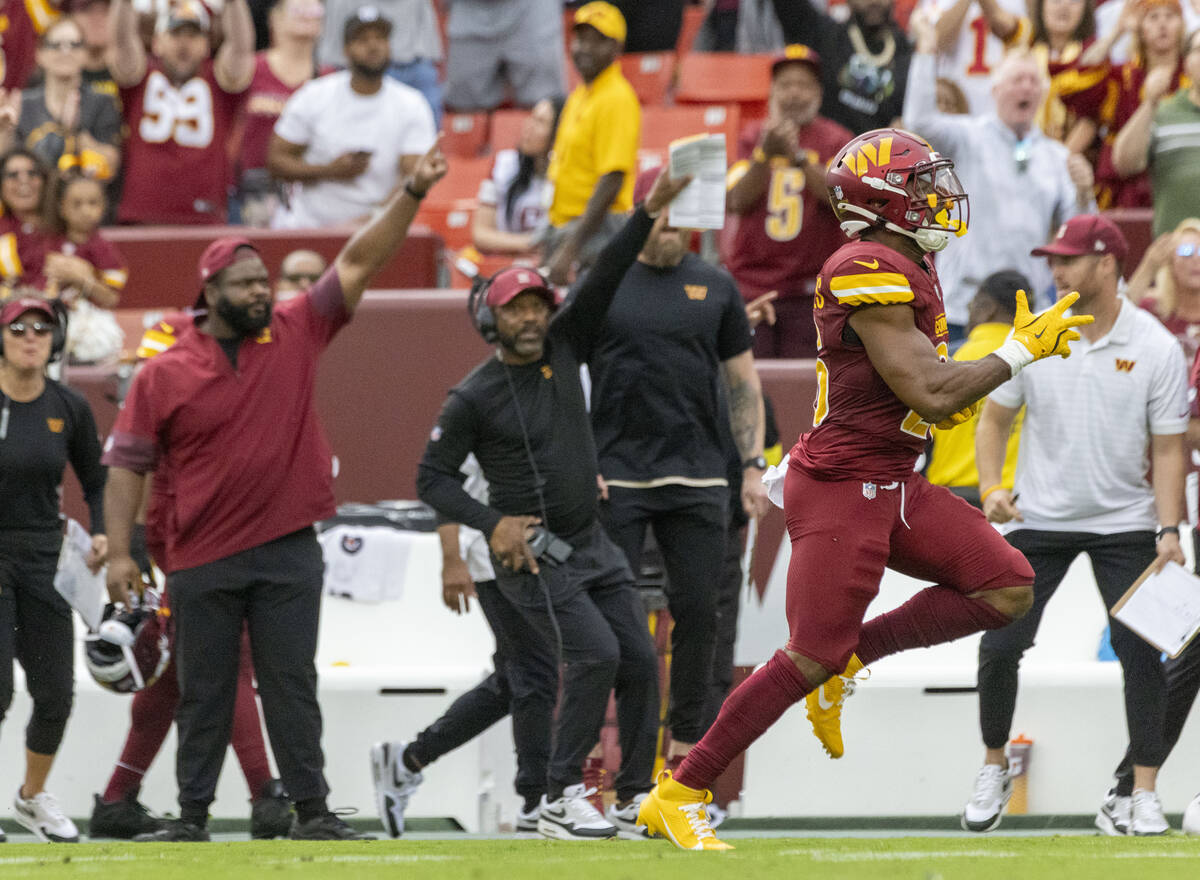 Washington Commanders running back Jeremy McNichols (26) runs as his team’s sideline poi ...