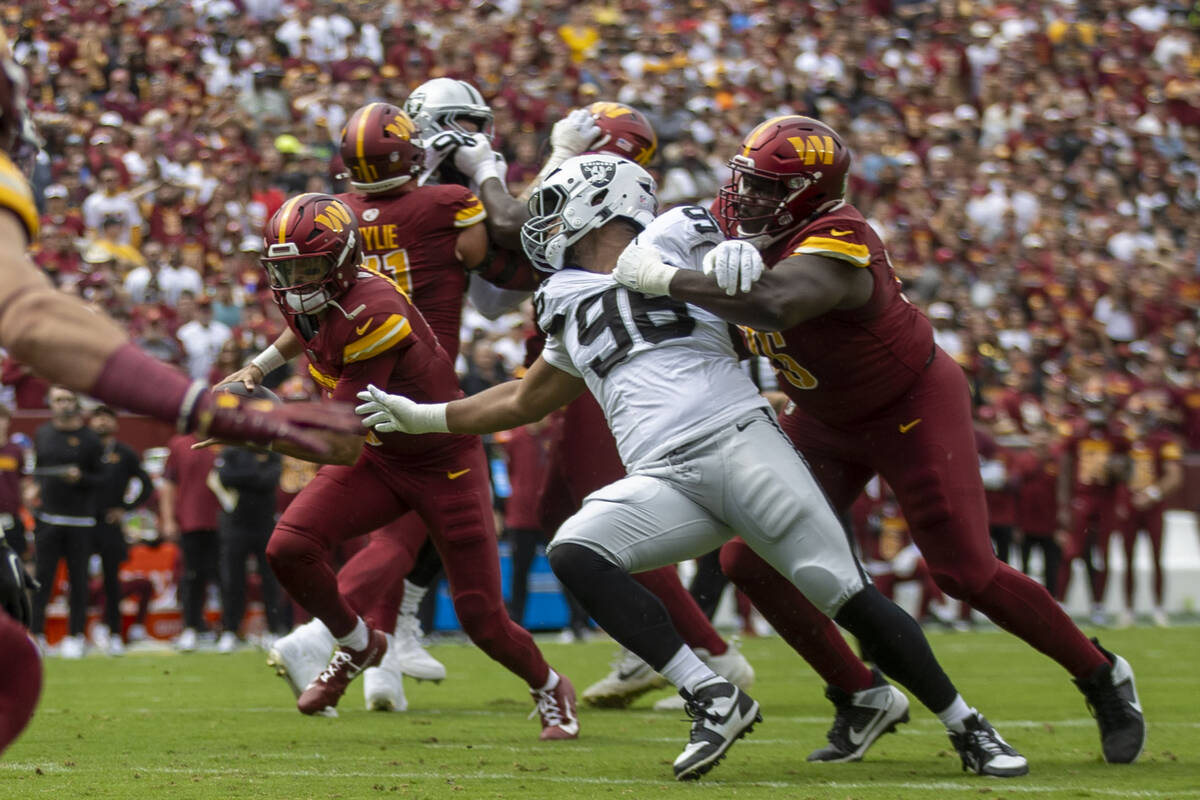Raiders defensive tackle Jonah Laulu (96) can’t make a tackle as Washington Commanders q ...