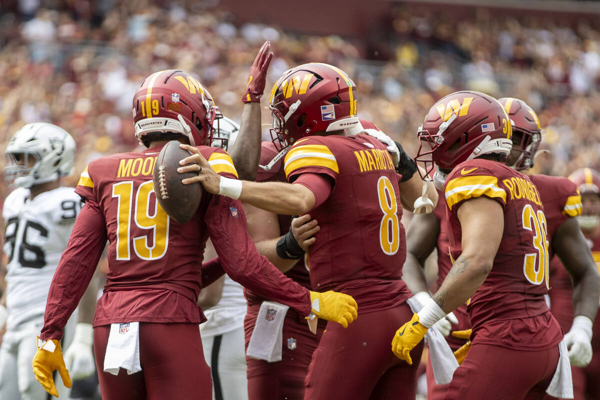 Washington Commanders quarterback Marcus Mariota (8) celebrates his touchdown with wide receive ...