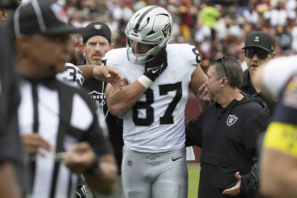 Raiders tight end Michael Mayer (87) comes off of the field with the help of trainers after suf ...