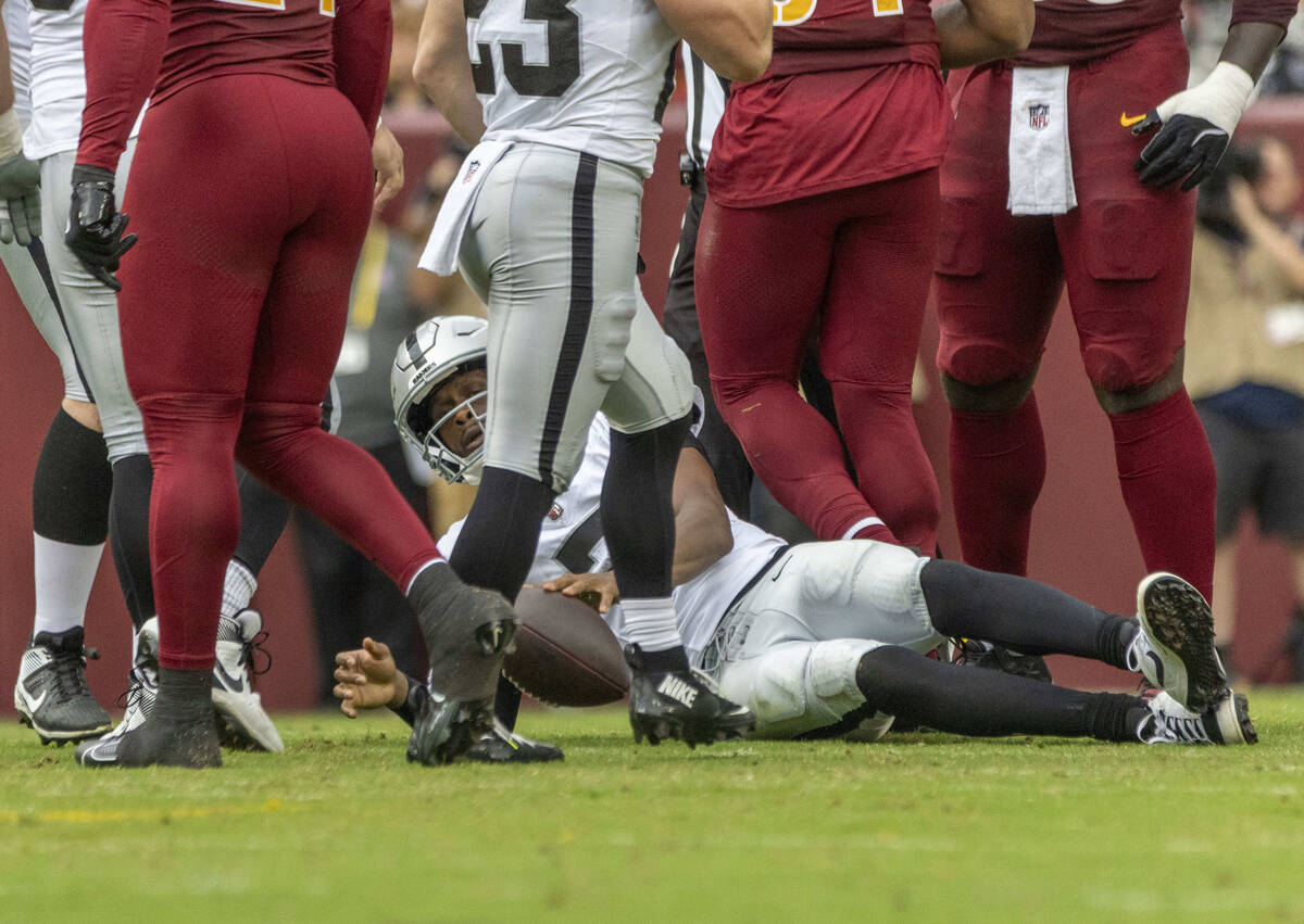 Raiders quarterback Geno Smith (7) gets up after being sacked during the first half of an NFL g ...