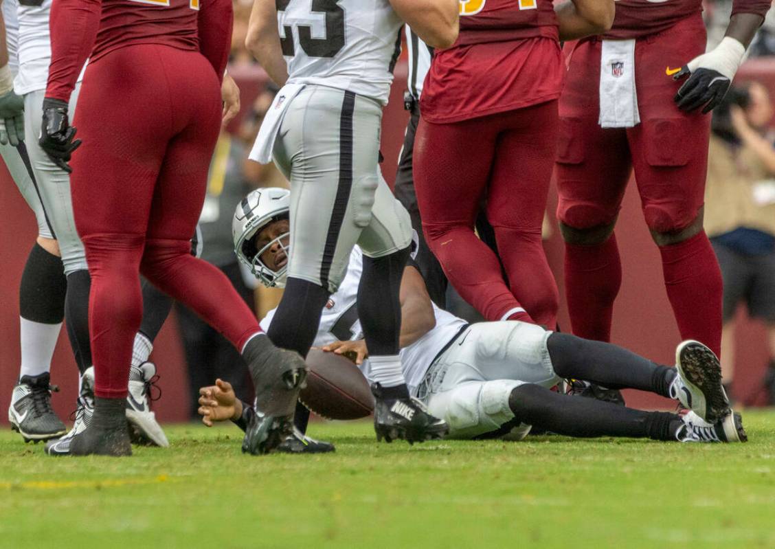 Raiders quarterback Geno Smith (7) gets up after being sacked during the first half of an NFL g ...