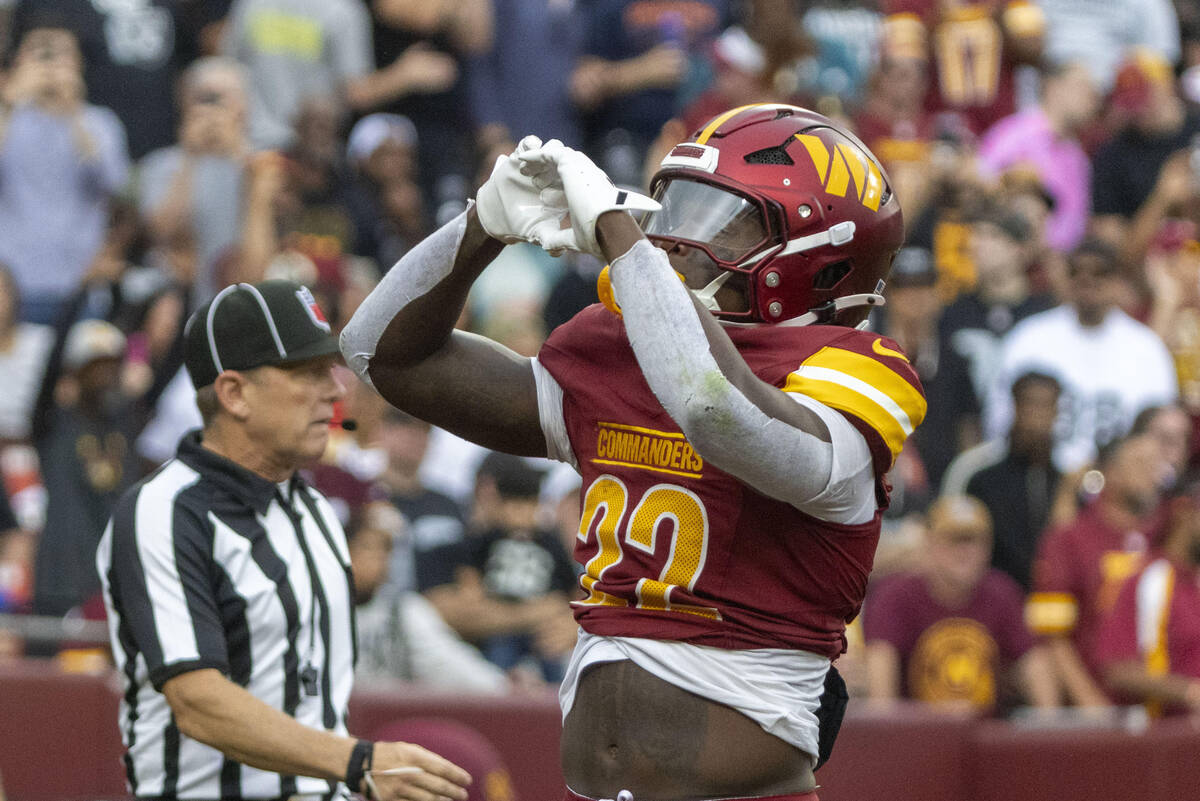 Washington Commanders running back Jacory Croskey-Merritt (22) makes a heart with his hands tow ...