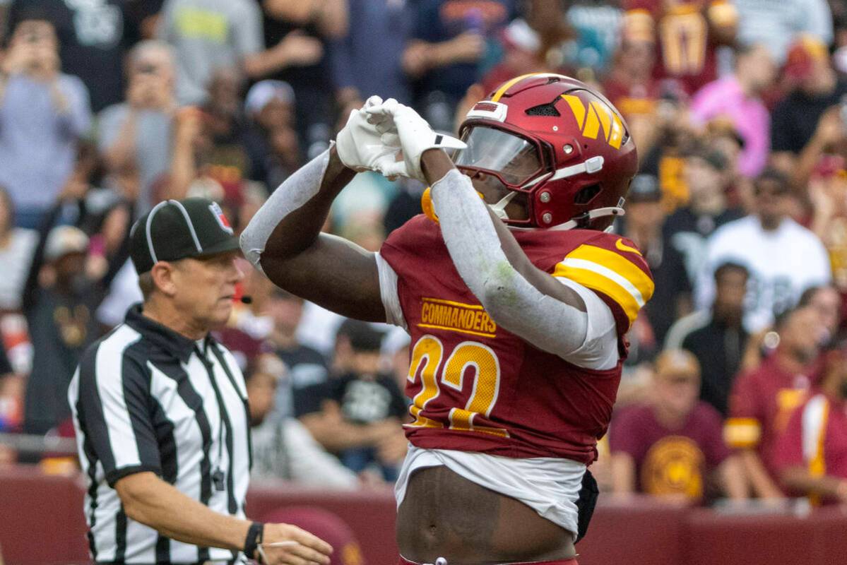 Washington Commanders running back Jacory Croskey-Merritt (22) makes a heart with his hands tow ...