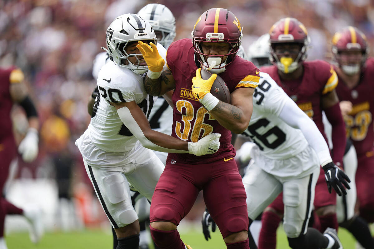 Las Vegas Raiders safety Isaiah Pola-Mao (20) defends as Washington Commanders running back Chr ...