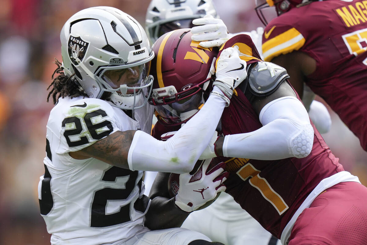 Washington Commanders wide receiver Deebo Samuel (1) is tackled by Las Vegas Raiders cornerback ...