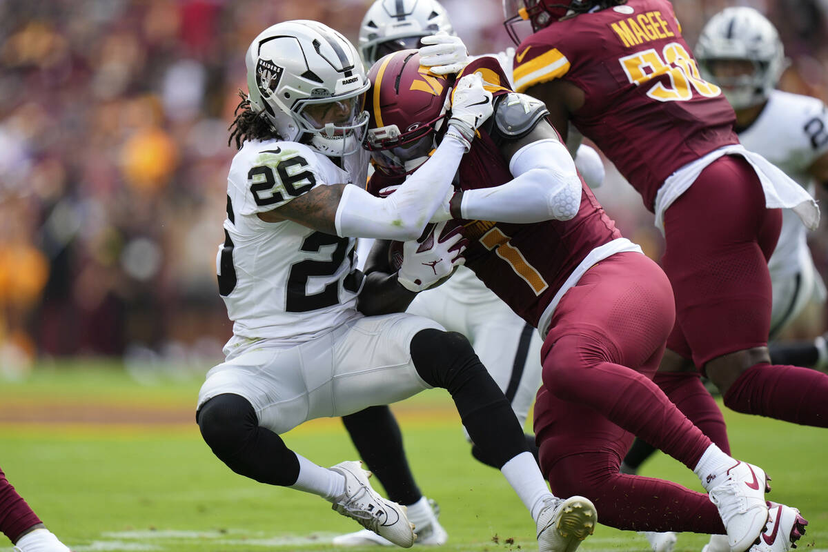Washington Commanders wide receiver Deebo Samuel (1) holds on to the ball as Las Vegas Raiders ...