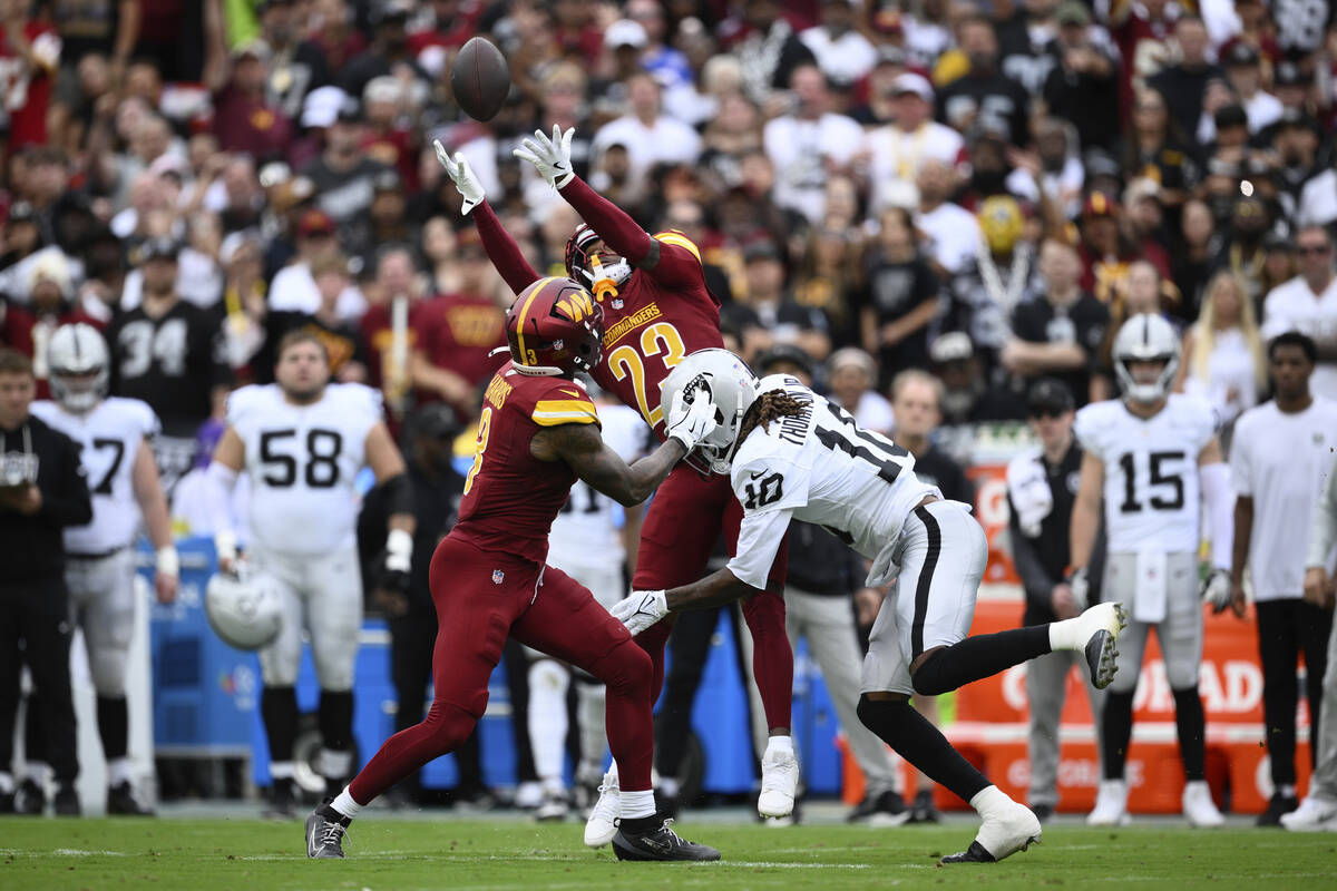 Washington Commanders cornerback Trey Amos (23) tries to get the ball after breaking up a pass ...