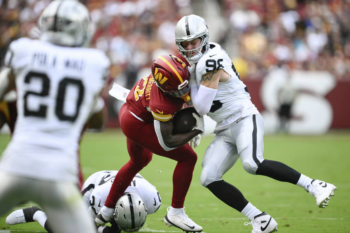 Las Vegas Raiders defensive end Maxx Crosby (98) tackles Washington Commanders running back Jac ...