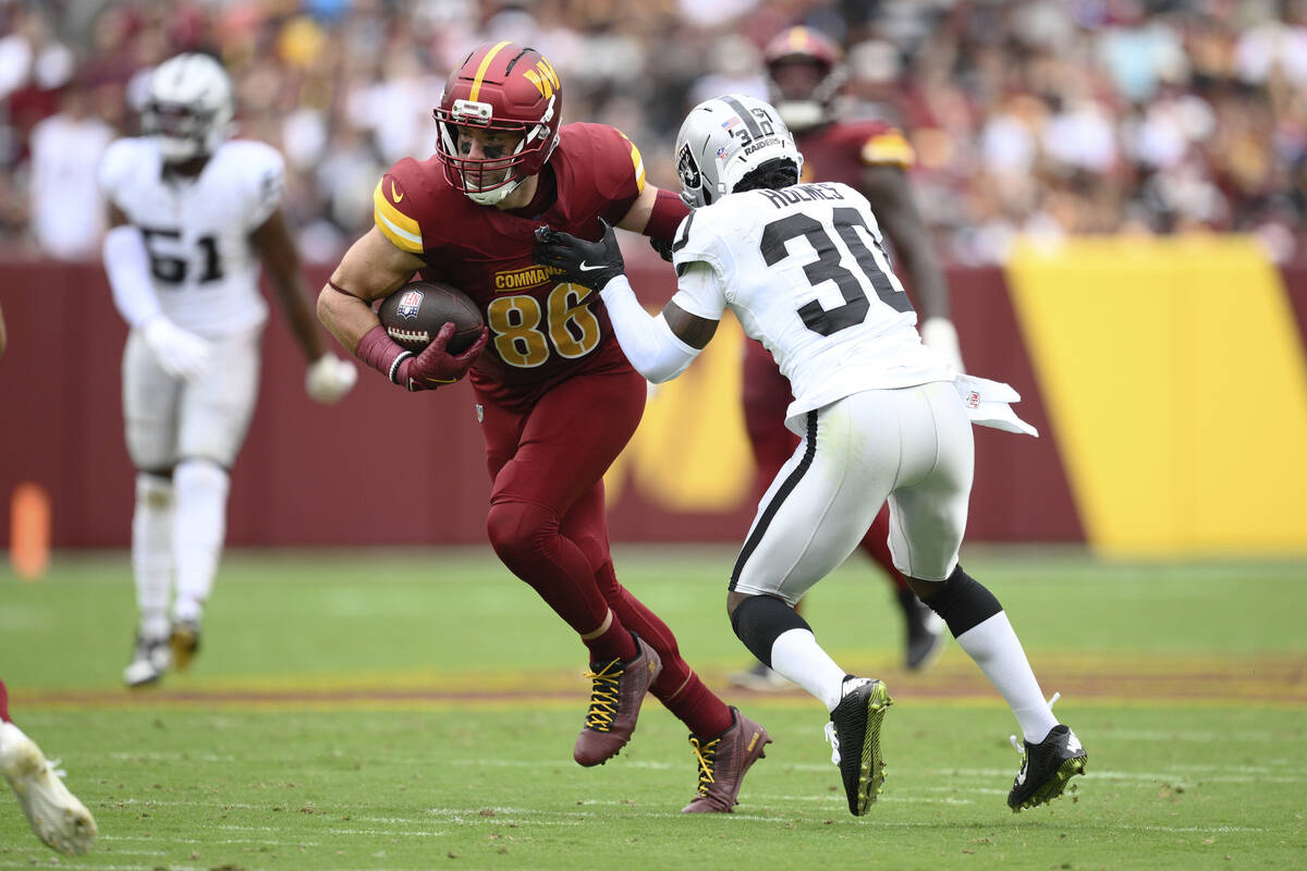 Washington Commanders tight end Zach Ertz (86) runs with the ball as Las Vegas Raiders cornerba ...