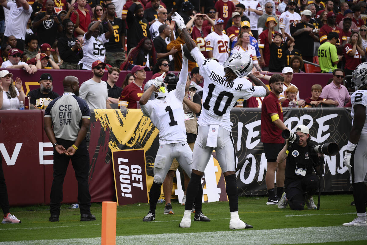 Las Vegas Raiders wide receiver Tre Tucker (1) celebrates with wide receiver Dont'e Thornt ...