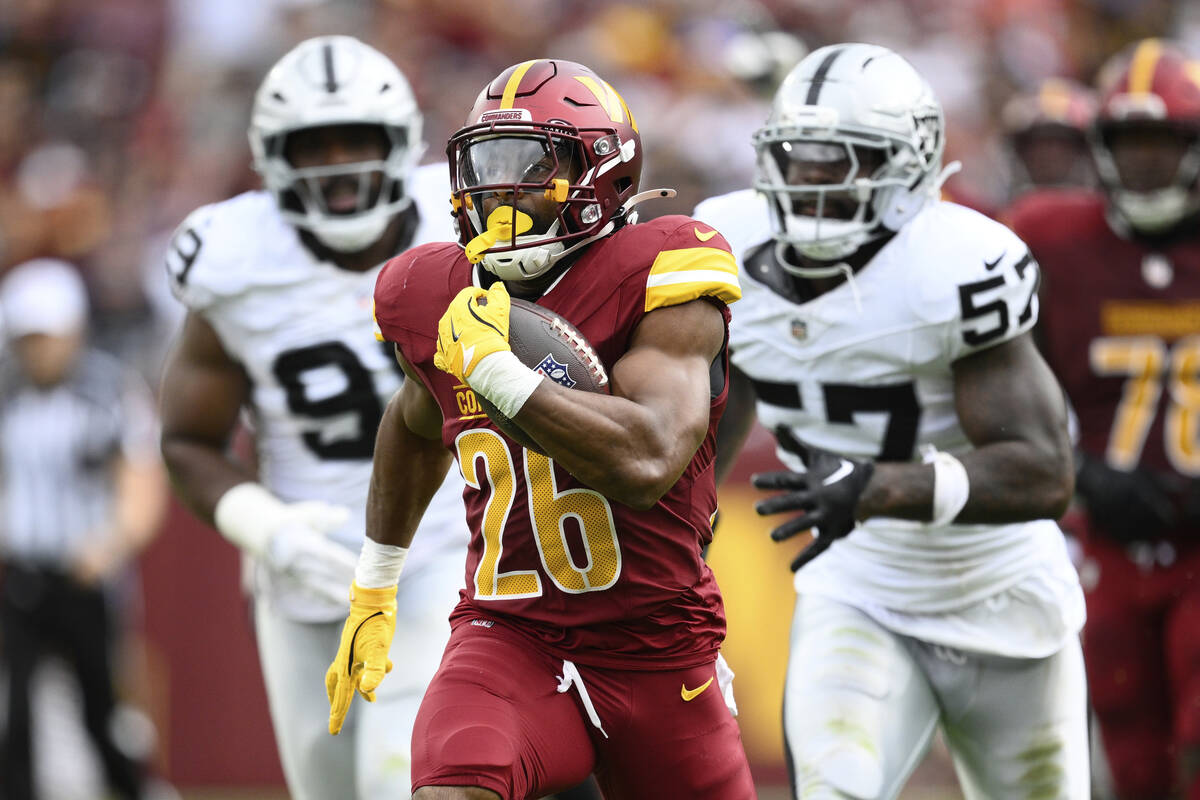 Washington Commanders running back Jeremy McNichols (26) runs in a touchdown during the first h ...