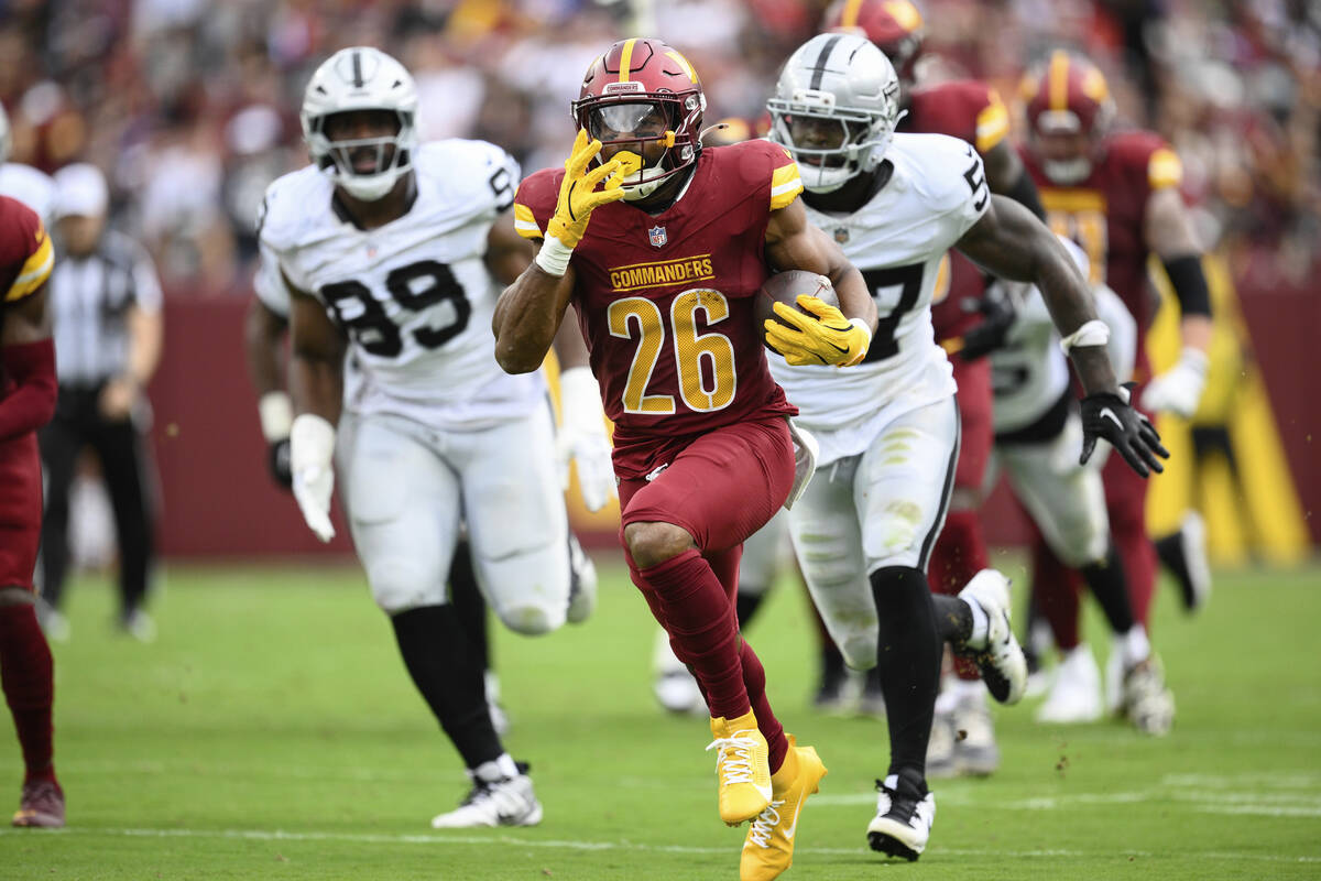 Washington Commanders running back Jeremy McNichols (26) runs in a touchdown during the first h ...