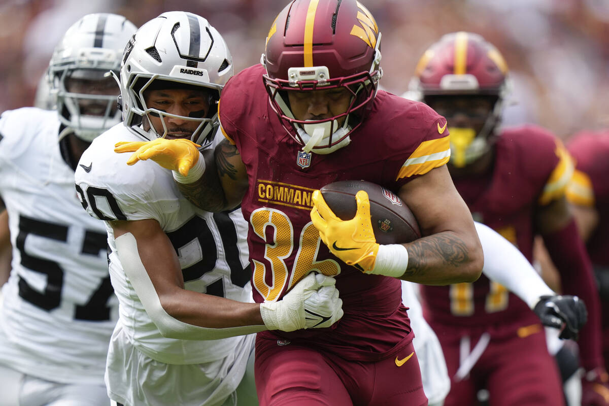 Las Vegas Raiders safety Isaiah Pola-Mao (20) defends as Washington Commanders running back Chr ...