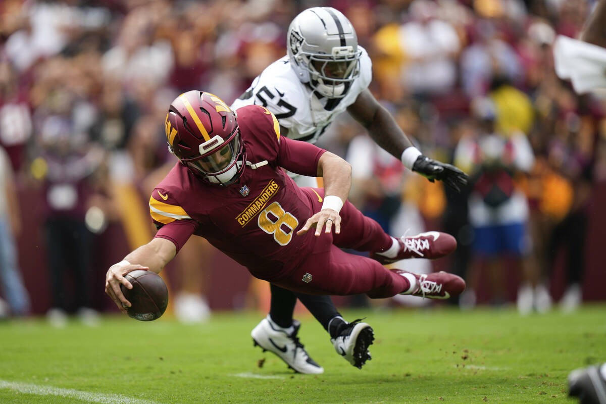 Washington Commanders quarterback Marcus Mariota (8) scores a touchdown during the first half o ...