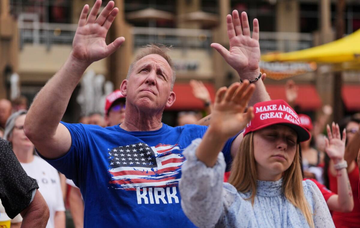 People listen to a worship song in the overflow area outside before a memorial for conservative ...