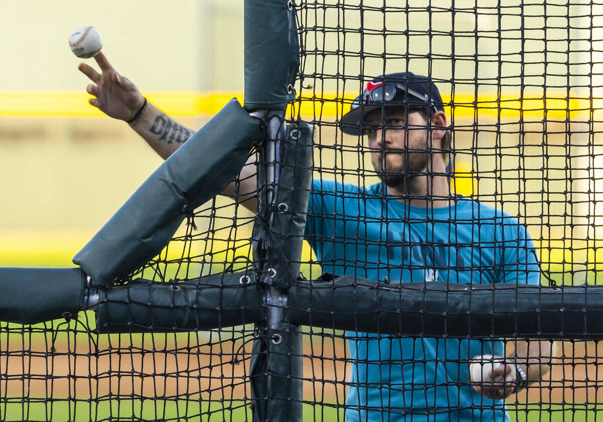 A Tacoma Rainiers' coach tosses a ball in batting practice before Game 1 of the Pacific Co ...