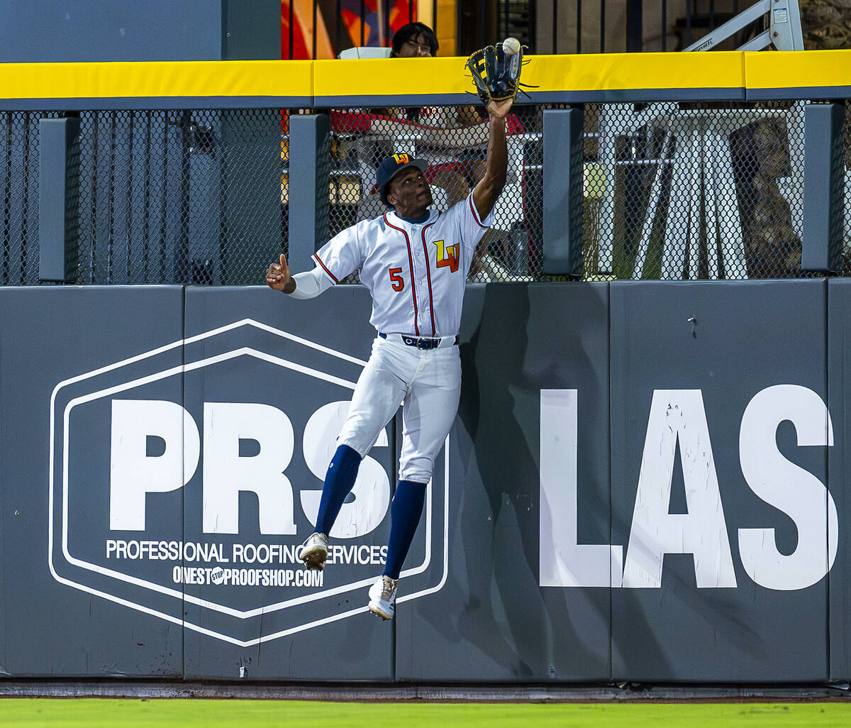 Aviators outfielder Denzel Clarke (5) elevates at the wall for an out against the Tacoma Rainie ...