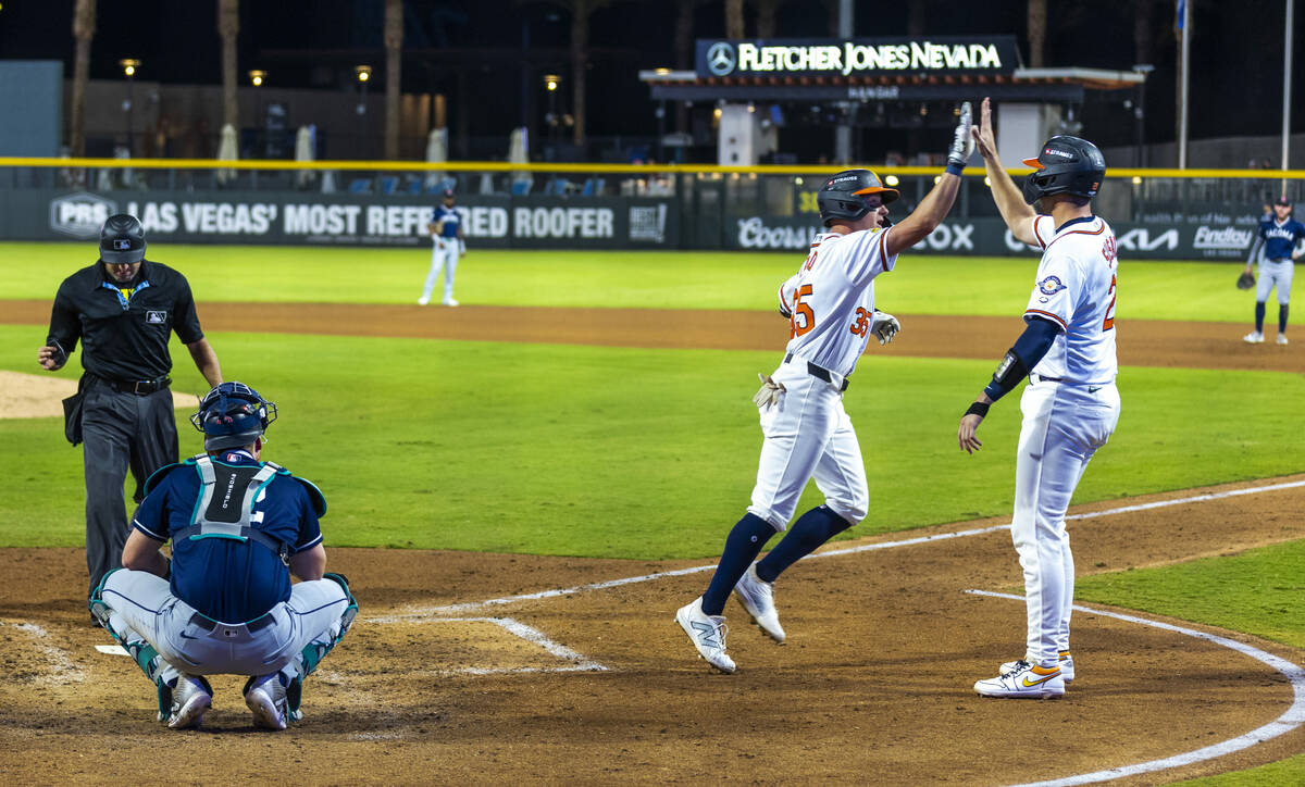 Aviators outfielder Ryan Lasko (35) is congratulated on a run by teammate catcher Daniel Susac ...