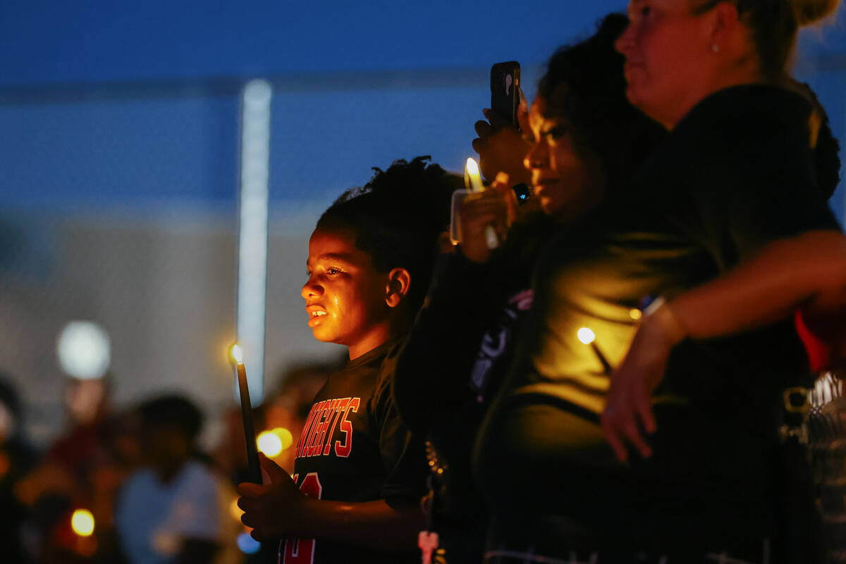Attendees raise faux candles during a vigil in Jovonn “JoJo” Magee-Thomas' honor on Wednesd ...