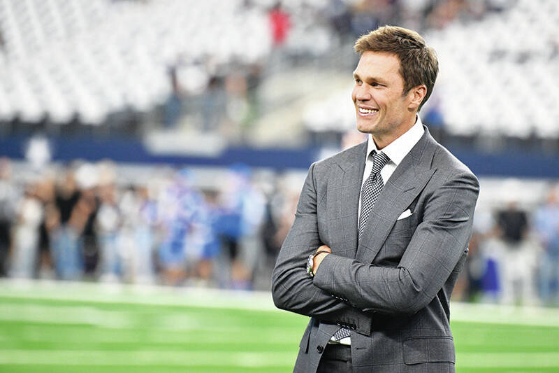 Analyst Tom Brady stands on the field during warmups before first an NFL football game between ...