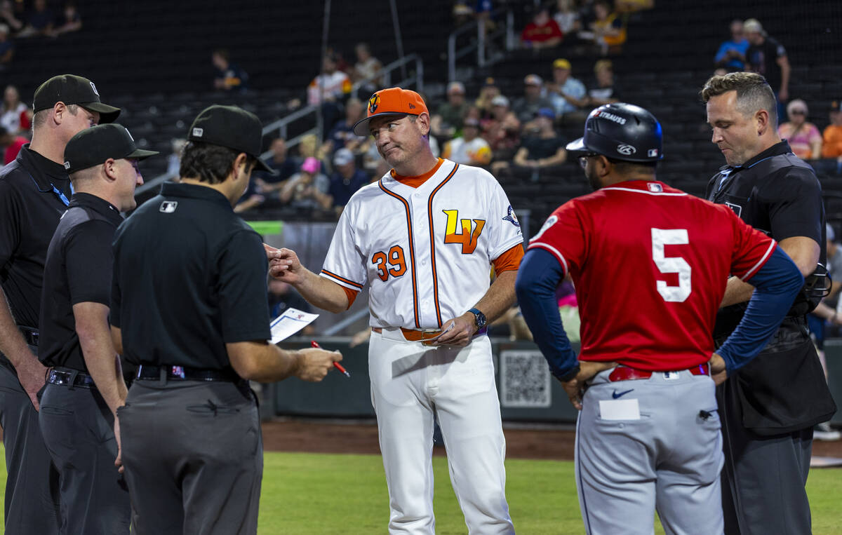 Aviators manager Fran Riordan talks with officials and a Tacoma Rainiers coach before Game 2 of ...