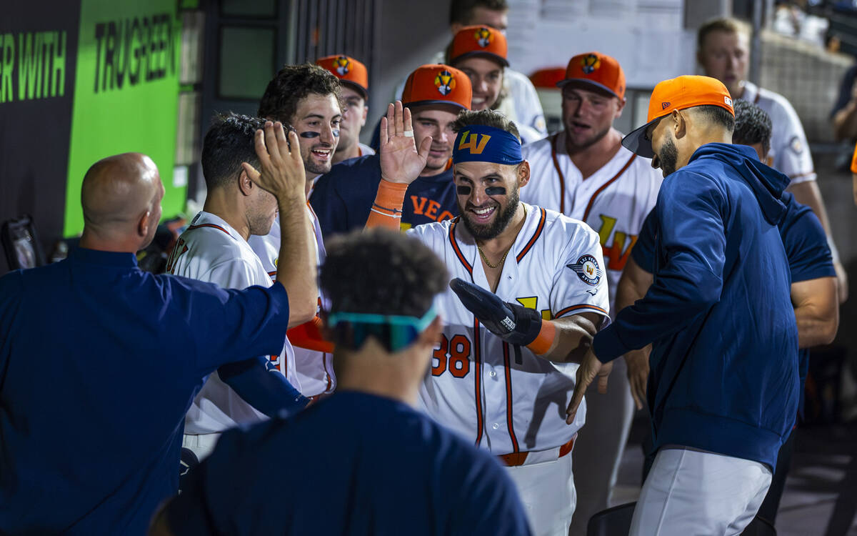 Aviators outfielder Nick Martini (38) celebrates a run scored with teammates in the dugout agai ...