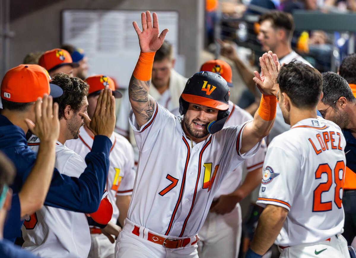 Aviators catcher Bryan Lavastida (7) celebrates a run scored with teammates in the dugout again ...