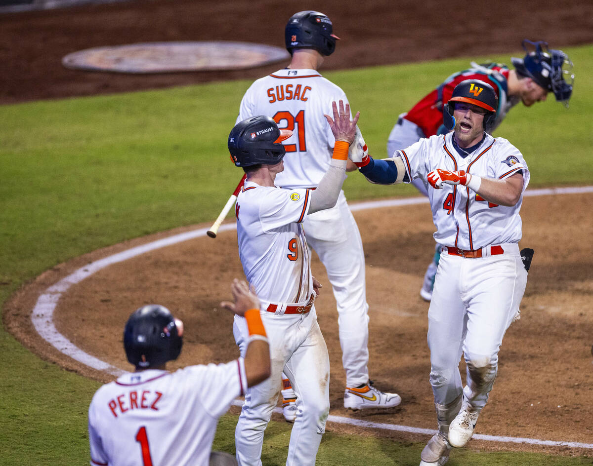 Aviators infielder Luke Mann (4) celebrates a two-run homer with infielder Cooper Bowman (9) th ...
