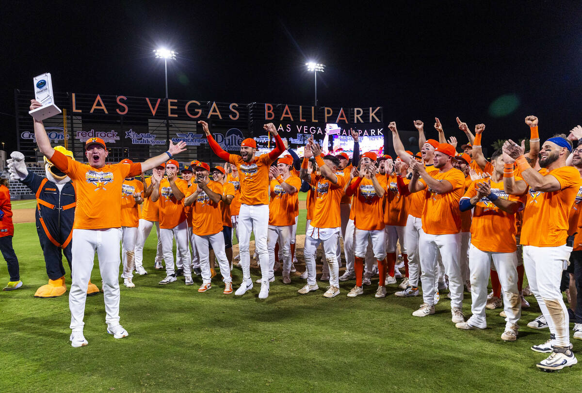 Aviators manager Fran Riordan holds the trophy as he and players celebrate their win over the T ...
