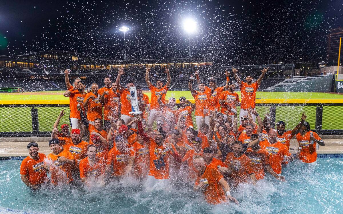 Aviators manager Fran Riordan joins his players with their trophy as they celebrate their win o ...