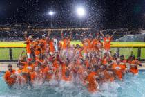 Aviators manager Fran Riordan joins his players with their trophy as they celebrate their win o ...
