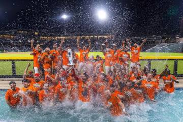 Aviators manager Fran Riordan joins his players with their trophy as they celebrate their win o ...