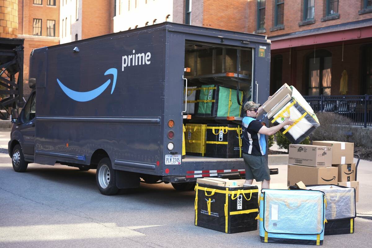 An Amazon Prime driver makes a delivery outside an apartment building in Pittsburgh, March 10, ...