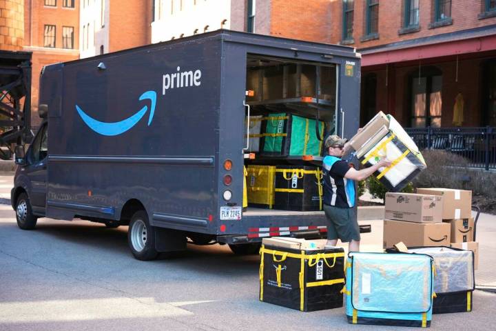 An Amazon Prime driver makes a delivery outside an apartment building in Pittsburgh, March 10, ...