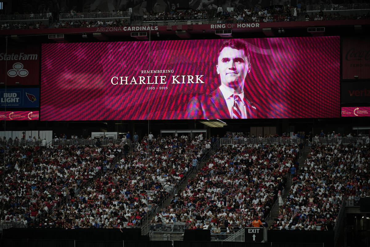 A photo of the conservative activist Charlie Kirk is seen on a large screen during a memorial f ...