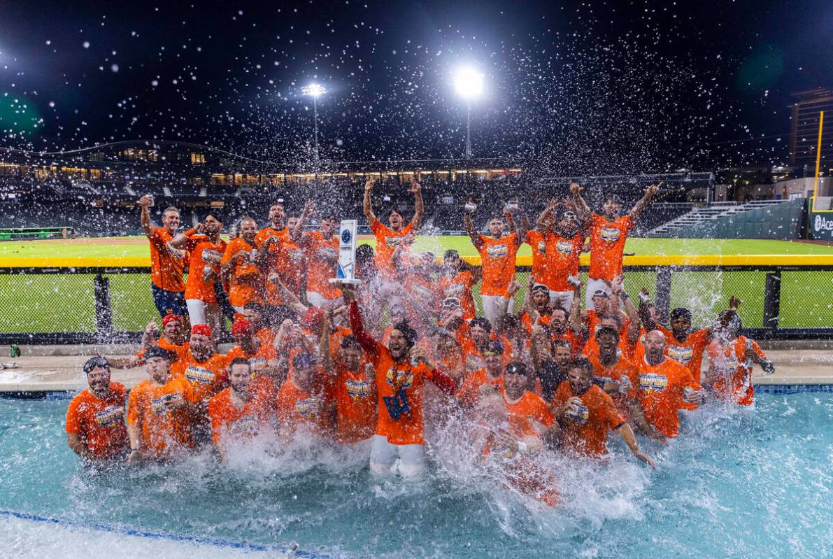 Aviators manager Fran Riordan joins his players with their trophy as they celebrate their win o ...